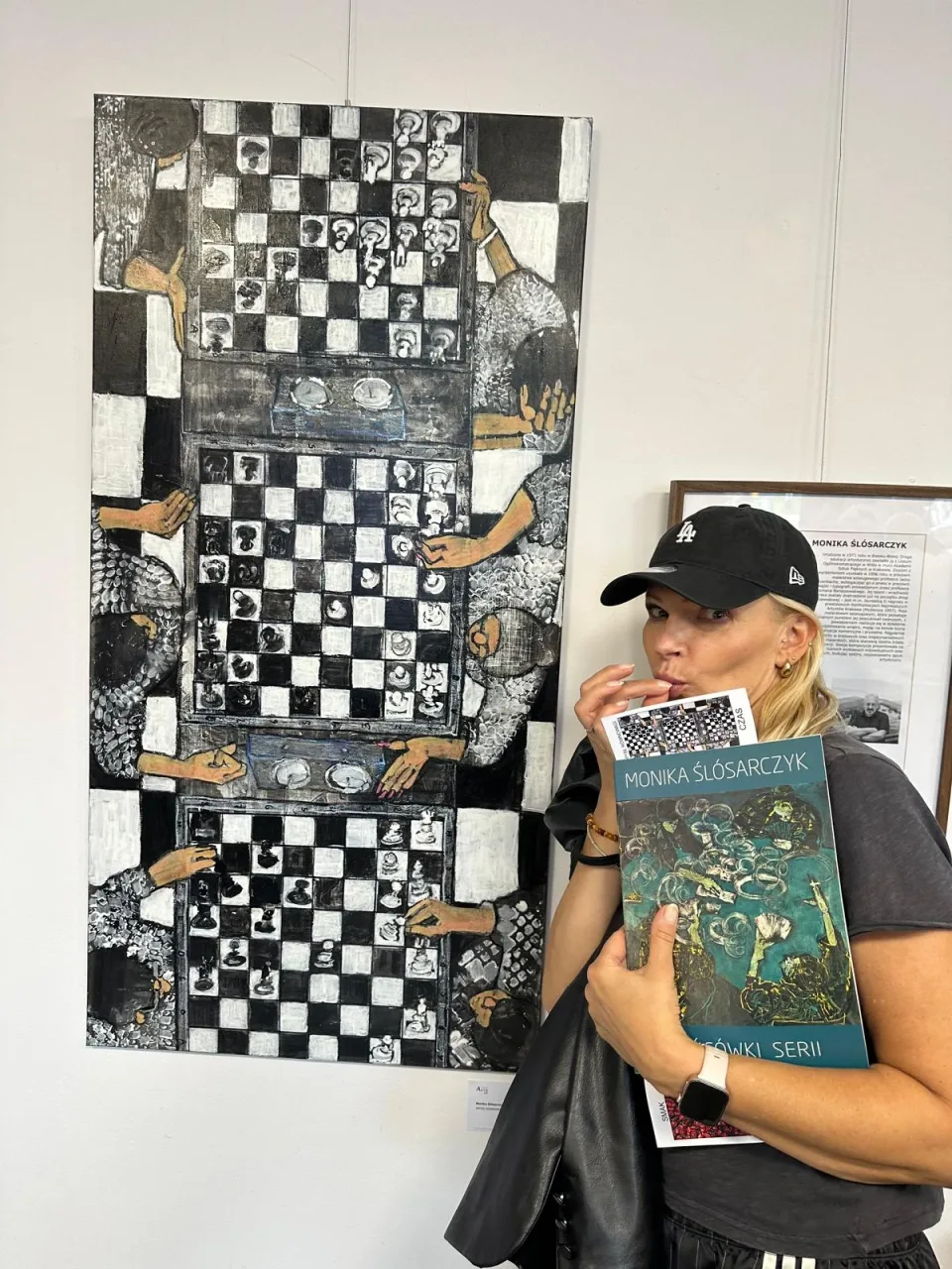Guest holding a Monika Ślósarczyk catalogue during the opening of Między piekłem a niebem at Arteon in Warsaw.