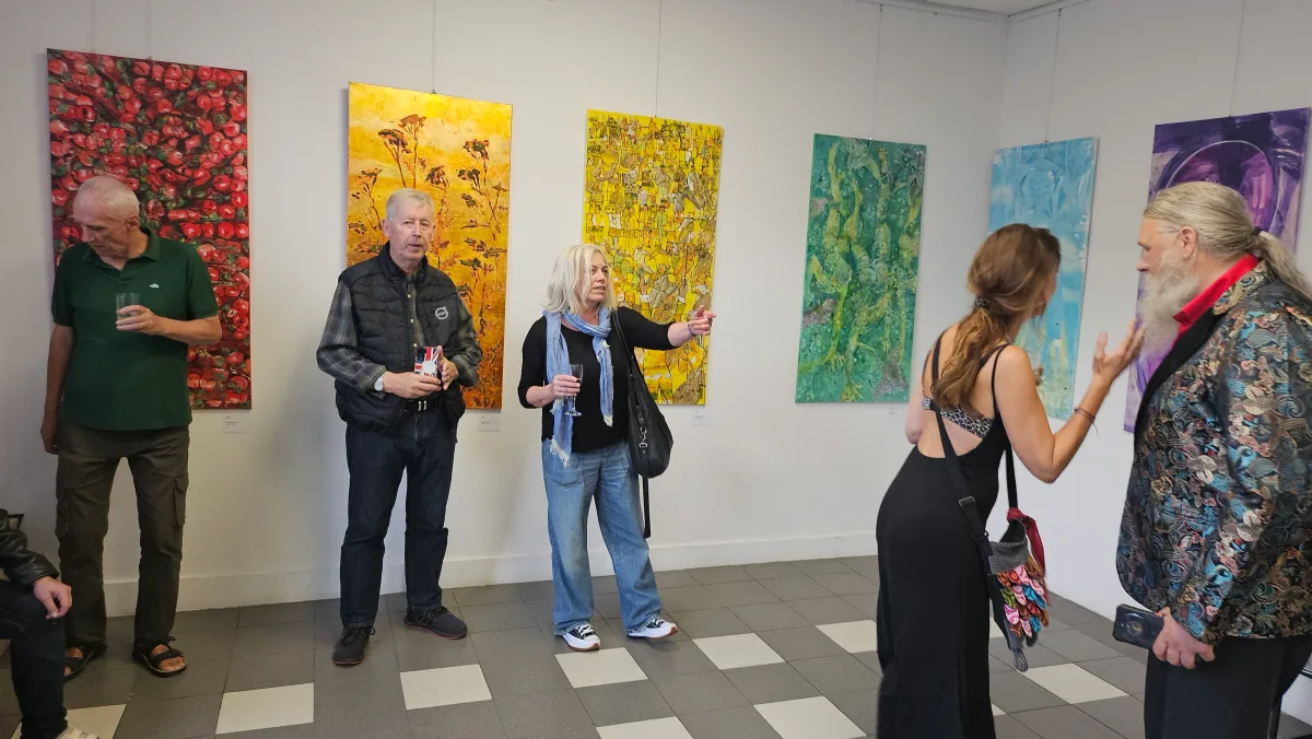 Visitors viewing paintings during the opening of Między piekłem a niebem at Arteon in Warsaw.